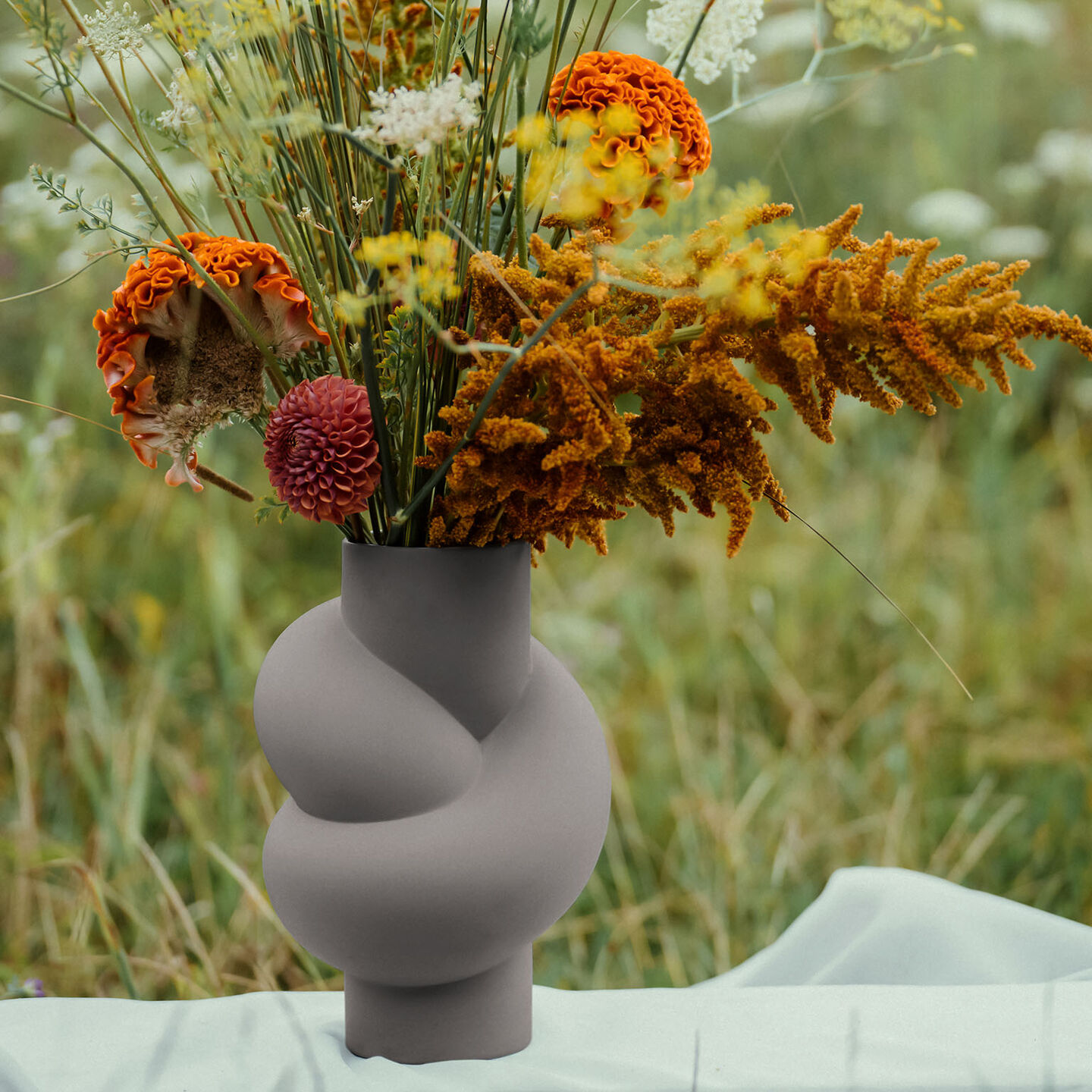 Rosenthal Node Grey vase filled with orange-yellow flowers