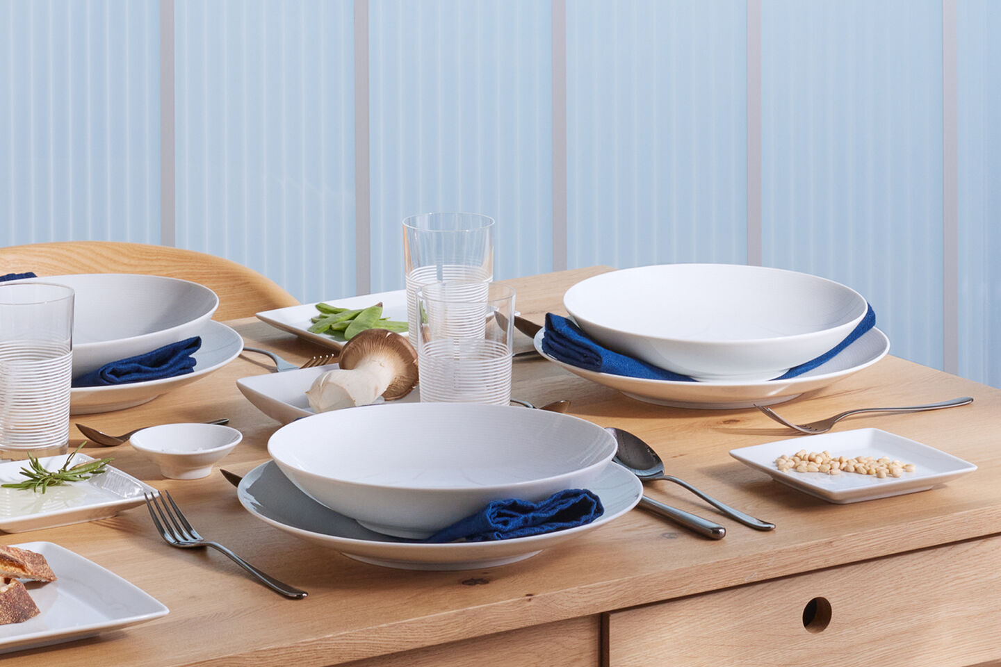 Table set with dinnerware on blue-colored linen table cloth
