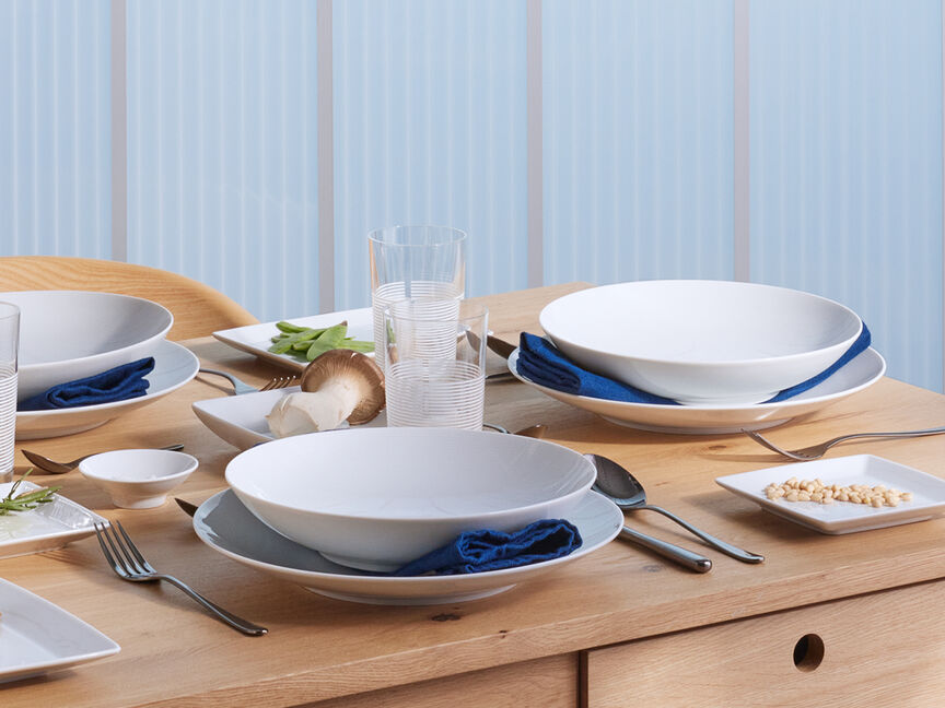 Large Family Brunch: Stylish Dinnerware Sets Table set with dinnerware on blue-colored linen table cloth