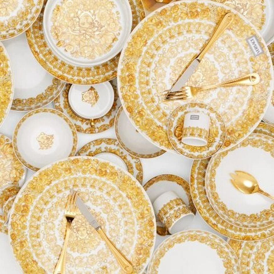 Various colorful Versace plates on colorfuly and lavishly decorated carpet.