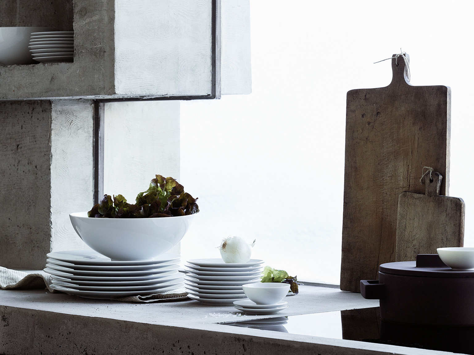 Rosenthal Tac White plates stacked on top of each other with a big bowl on top with salad & onion as decoration