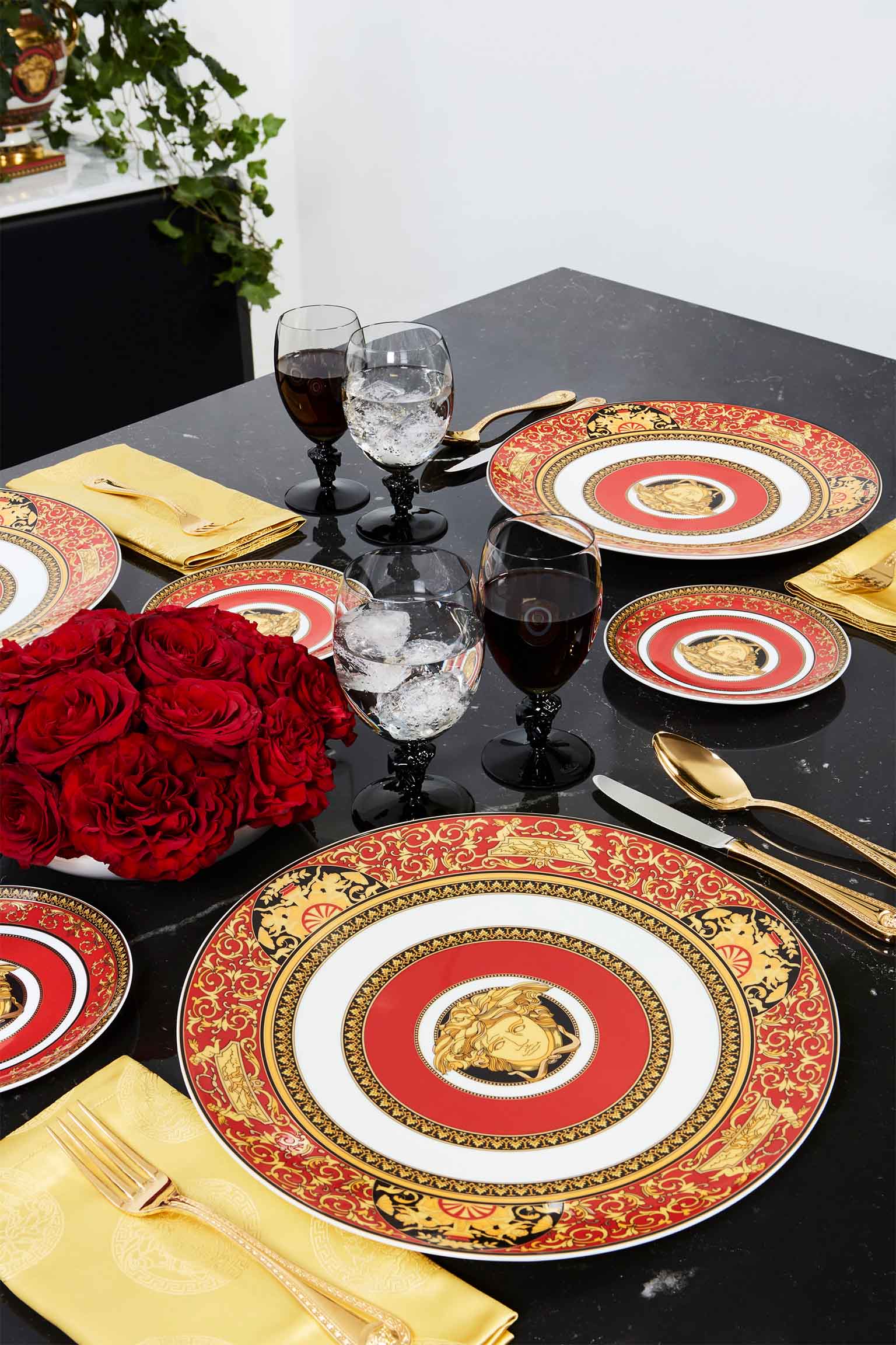 Rosenthal meets Versace Medusa Red plates on black table with red roses